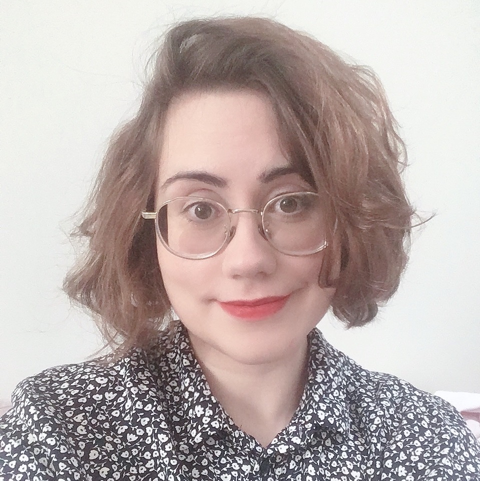 Photo of Emma Winston, a woman with dark hair, glasses and a floral shirt smiling at the camera.